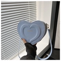Close-up of heart-shaped crossbody bag in light blue faux leather with gold fashion text - Blue