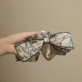 Eleganter beiger Schleifen-Haarclip mit blau-braunem Blattmuster und feinem schwarzem Rand - Weißes Muster