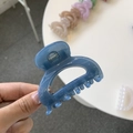 Close-up of a blue acrylic square hair claw clip held by hand showing premium finish - Haze Blue
