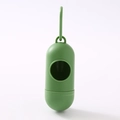 Detail of green capsule dog waste bag dispenser with hook on white background - Dark Green