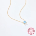 Macro shot of S925 sterling silver gold chain with a square blue zircon pendant - 925 Silver / Gold/Blue Zirconia
