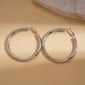 Orecchini a cerchio minimalisti in argento con finitura lucida su sfondo neutro - Lucido / 6cm / Argento