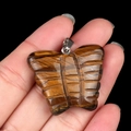 Tiger eye butterfly pendant with silver bail shown held by hand for size reference - Tiger's Eye
