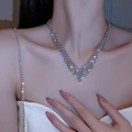 Elegantes silbernes V-Förmiges Choker-Halskette mit funkelnden Strasssteinen am Modell - Silberne V-Form Halskette mit Vollstrass-Quaste