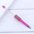 Pink rhinestone DIY beaded ballpoint pen with metallic accents on white wood surface - Black Ink / Rose Red