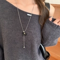 Detail showing a silver chain necklace with a black horse pendant and a small gold star charm - Polished Smooth Style / Black