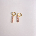 Détail de créoles dorées avec pampilles en zircon rose en cascade sur cuir blanc - Or + Rose (DEK1399)