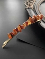 Vue détaillée d'une barrette en cristal orange sur un support doré vintage - Or & Agate Rouge