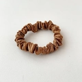 Detail showing the smooth satin texture and elegant folds of the caramel brown scrunchie - Dark Brown
