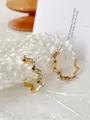 Macro detail of gold irregular geometric earrings with inlaid rectangular clear zircons - Wavy White