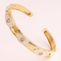 Detailed view of gold C-shaped cuff bracelet with white enamel evil eye and inlaid crystals - White Enamel Style (SL99-3)