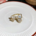 Vista macro di un anello a fiocco in oro 14k con madreperla e pietre di zirconi - Oro