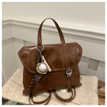 Detail of vintage brown tote backpack featuring retro metal buckles and baseball charm - Brown with Pendant
