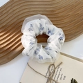 Detail der floralen blauen Haargummi-Textur mit zweilagigem weißem Organza-Netzgewebe - Floral Muster Lila