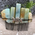 Detail of natural crystal hair comb with silver moon and star charms on mossy ground - Amazon Stone Black Wire Silver Moon