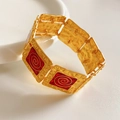 Dettaglio di un bracciale smaltato vintage in metallo martellato dorato e spirali rosse - Base Oro Spirale Rossa / Oro-Rosso