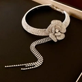 Detailed view of silver flower choker with sparkling rhinestone tassels on black velvet box - Camellia Tassel Style / Silver