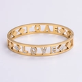 Detalle del brazalete LOVE dorado con pedrería capturado desde un ángulo de 45 grados - Dorado