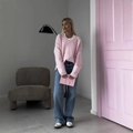 Relaxed pink V-neck knit sweater paired with blue wide-leg jeans in a minimalist room - S / Pink