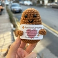 Handmade crochet positive potato doll held by hand with motivational German card text - Dark Brown V-Mouth Potato