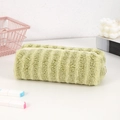 Detail van het lichtgroene pluchen etui met gestreepte textuur en een witte ritssluiting - Groen