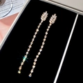 Macro view of 18K gold plated leaf fringe earrings with cubic zirconia in a jewelry box - Gold