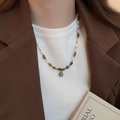 Close-up of tiger eye beaded necklace with turquoise teardrop pendant on a model - 24# Gold Brown Style