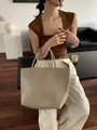 Beige woven straw tote bag held by a model in a stylish summer vacation outfit - Large / Beige