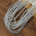 Primer plano de cuentas talladas de 4mm color opale sobre madera oscura para joyas DIY - Ópalo Blanco