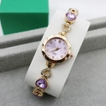 Detail of a ladies gold watch featuring a purple dial and heart-shaped jeweled bracelet - Rose Gold Purple