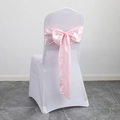 Pink satin chair sash tied in a large bow on a white wedding banquet chair cover - Light Pink
