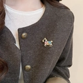 Detailed close-up of a pink and blue crystal horse brooch on a tweed blazer coat - Colorful Gemstone Inlaid Pony