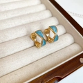 Makroaufnahme von Vintage-Goldohrringen mit blauem Emaille auf Samthintergrund - 32# Twisted Geometric Ear Buckle Style / Gold/Blau