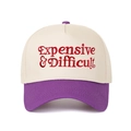 Close-up of red 'Expensive & Difficult' embroidery on a two-tone baseball cap - Cream/Purple