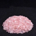 Polished natural rose quartz crystal chips stacked on a minimalist dark matte background - Rose Quartz / 100 g