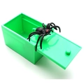 Detail shot of a green plastic prank box with a realistic black spider popping out - Green