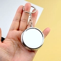 Polished silver round metal pill box keychain with mirror finish held in hand - No Compartment Round With Keychain