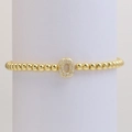 Macro shot of gold beaded bracelet with an oval charm set with sparkling cubic zirconia - Letter O