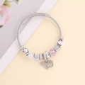 Bracelet à breloques argenté avec cœur en émail rose et étoiles sur fond de magazine fleuri - Rose