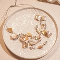 Detail view of multi-layer shell necklace with iridescent beads and lobster clasp - White