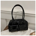 Detailed view of black glossy handbag with double front pockets on white fabric - Black