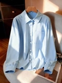 Plus size light blue long sleeve button-up shirt with front pocket on a wooden hanger - S / Light Blue