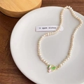 Elegante collana di perle con ciondolo a tulipano su piatto di ceramica e sfondo legno - Collana di Perle di Tulipano