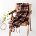 Plaid scarf in reddish brown with fringe details draped on a wooden chair - Red Brown Grid