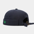 Detail of adjustable metal buckle and green clover embroidery on navy blue docker cap - Adjustable / Navy Blue