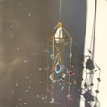 Detail of crystal sun catcher with white quartz and rainbow prism reflections on wall - 49-51cm / Gold Alloy + White Turquoise