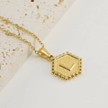 Hexagon gold plated stainless steel necklace featuring embossed letter L with beaded edge - Letter L (Single Pendant)