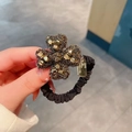 Fonkelende donkere kristallen klavertje vier haarelastiek met geplooid scrunchie - Bloem Goud