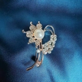Spilla a fiore oro rosa con perla bianca e strass scintillanti su seta blu scuro - Spilla Ipomea