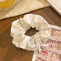 Detail of beige polka dot scrunchie with silk bow and star button on wood surface - Beige Polka Dot with Bow and Star Button